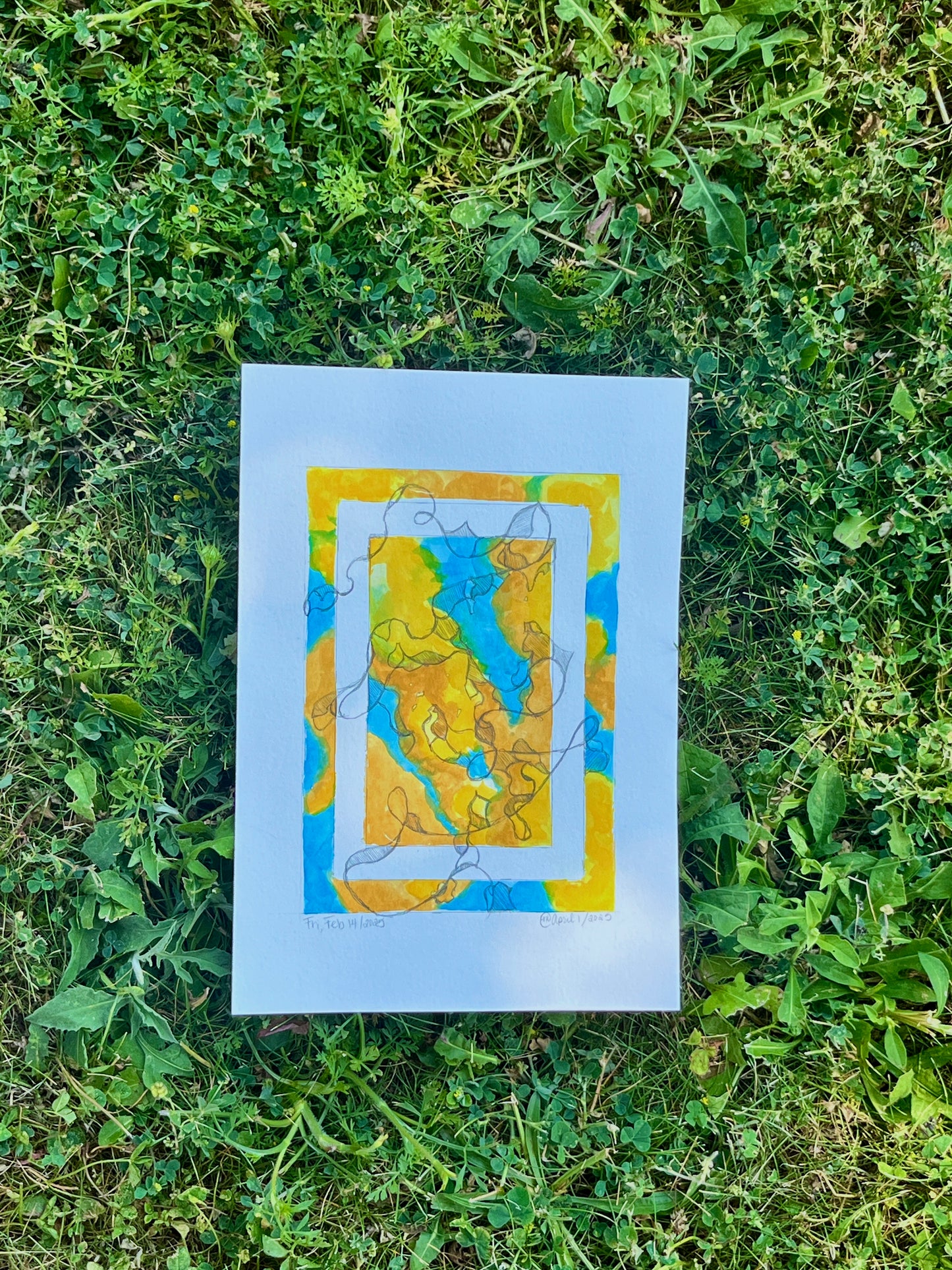 Bright, colourful abstract painting on paper laying in the grass