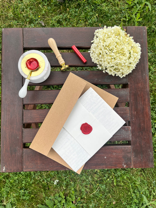 Letter with red wax seal on a wooden table outside