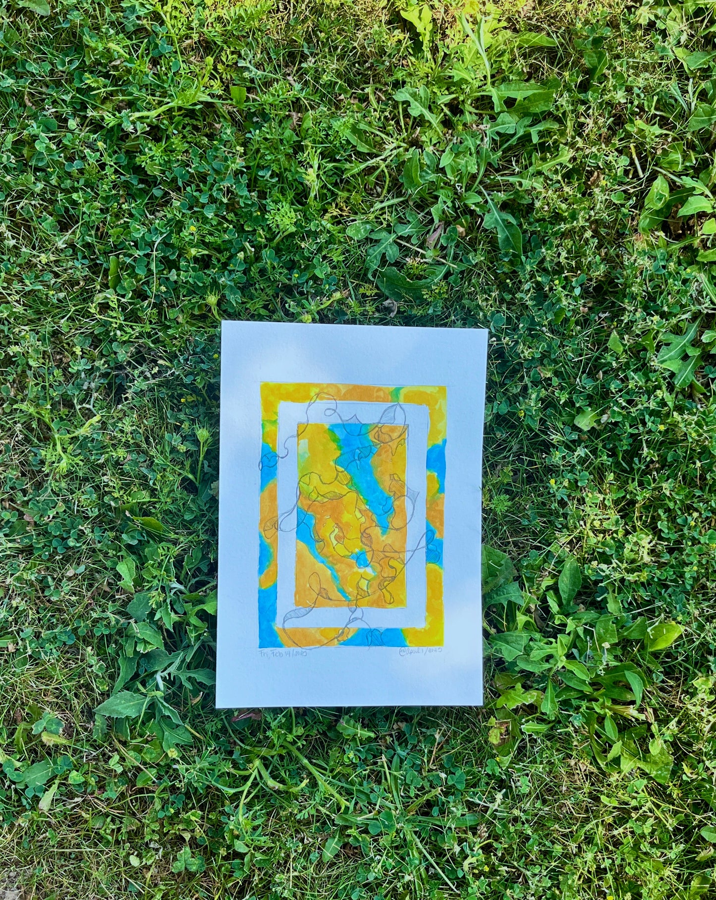 Colourful abstract painting with pencil overlay, placed in the grass and sunshine